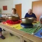 Ältere Personen auf einem schön gedeckten Tisch mit zwei Klangschalen